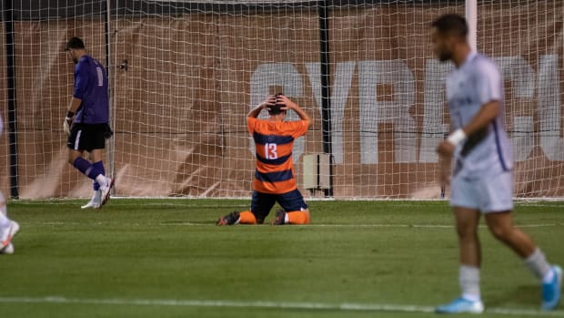 Syracuse's Colin Biros sits on his knees in front of the goal